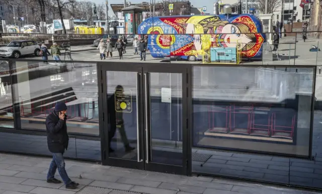 A man walks in front of windows of shuttered McDonald's restaurant in Moscow