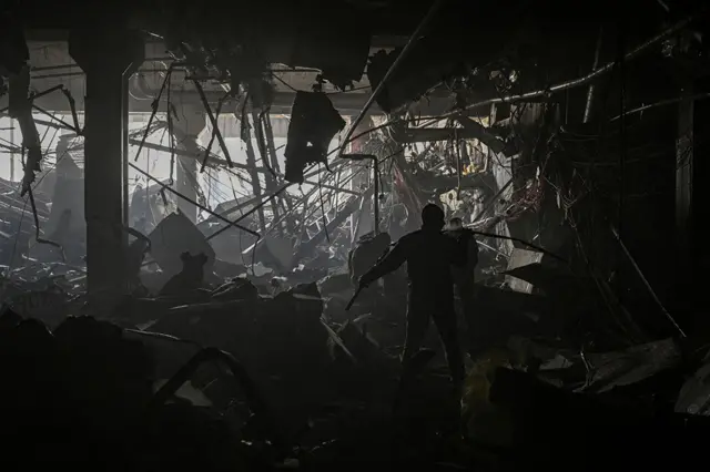 Ukranian serviceman walks between debris inside the Retroville shopping mall after a Russian attack on the north-west of the capital, Kyiv, on 21 March 2022