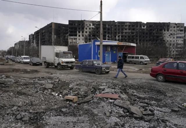 A civilian walks through rubble following heavy shelling in the Ukrainian city of Mariupol