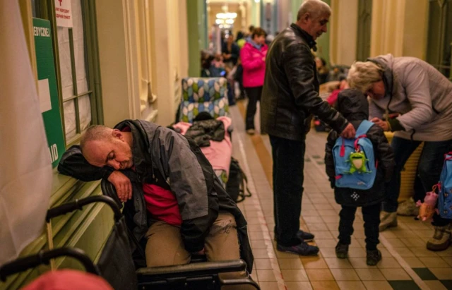 A Ukrainian evacuee sleeps in the railway station in Przemysl, near the Polish-Ukrainian border