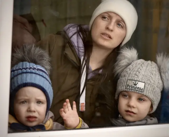 A mother and her children watch from the boat as they approach Romania