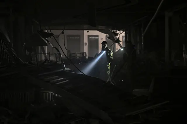 Ukranian serviceman walks between debris inside the Retroville shopping mall after a Russian attack on the north-west of the capital, Kyiv, on 21 March 2022