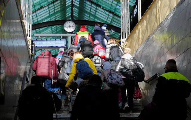 Refugees fleeing Russia's invasion of Ukraine climb station steps, at the central station in Goerlitz, Germany