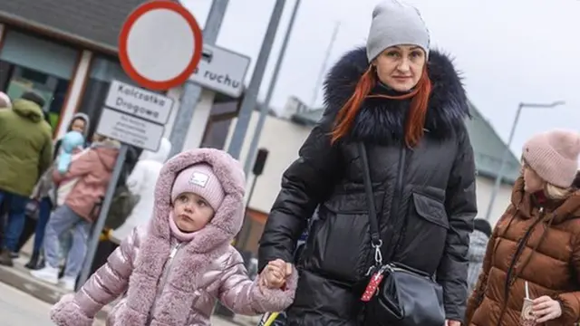 A woman holding a girl's hand