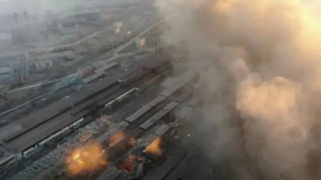 Multiple explosions and rising smoke are seen around an industrial compound, in Mariupol 22 March 2022