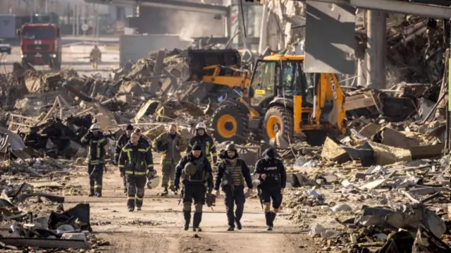 Firefighters inspect damage to a shopping mall outside of Kyiv