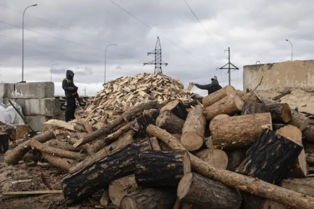 Territorial Defense fighters chop firewood at one of the road blocks near the city of Boryspil close to Kyiv, Ukraine, 8 March 2022