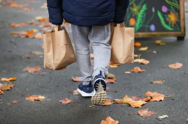 Child carrying packed lunches