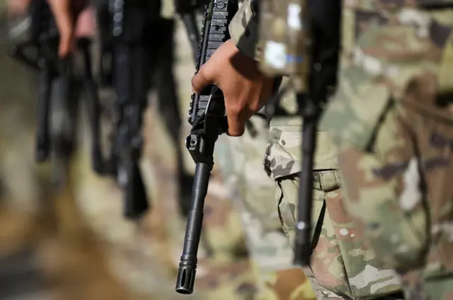 U.S. troops in transfer to military base in Grafenwoehr carrying rifles stand in formation at the Albrecht Duerer Airport in Nuremberg, Germany March 1, 2022.