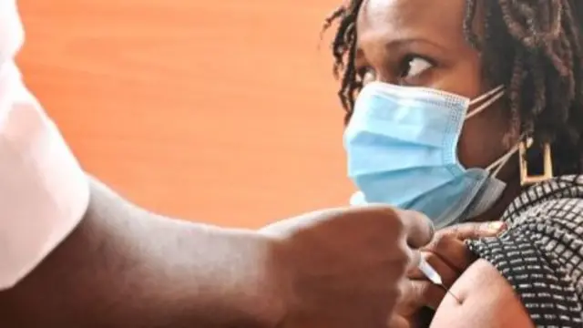 A Kenyan woman receives an injection with a dose of the Oxford/AstraZeneca Covid-19 vaccine at the Kenyatta national hospital in Nairobi - 3 August 2021