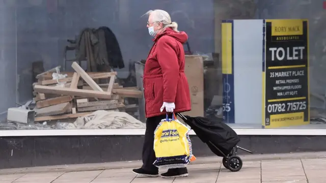 Person walking past derelict shop