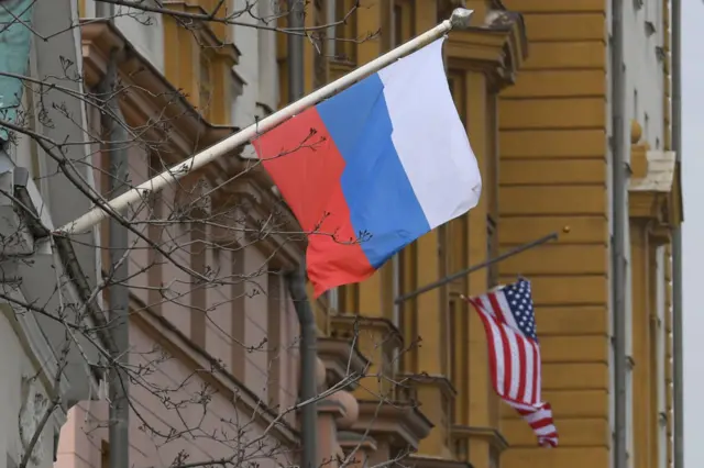 A Russian flag flies next to the US embassy building in Moscow on April 15, 2021.