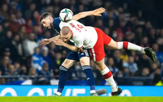 Ryan Christie challenges with Bartosz Salamon