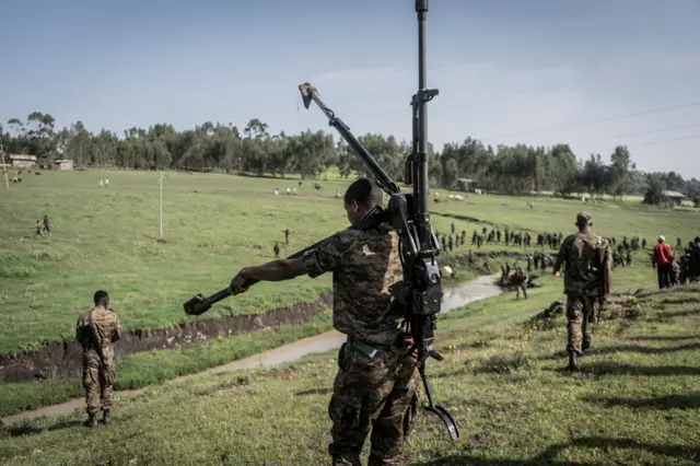 An Ethiopian National Defence Forces (ENDF) soldier carries a DShK 1938, a Soviet heavy machine gun, on his back during training