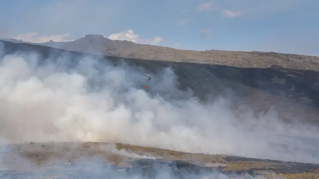 A helicopter dropping water on wildfires on Mount Kenya - March 2022