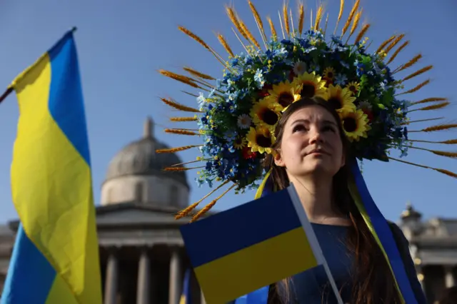 A woman in a headdress made of flowers in the colours of the Ukrainian flag