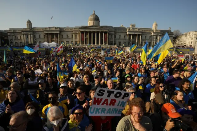 Crowds with Ukrainian flags and banners in Trafalgar Square