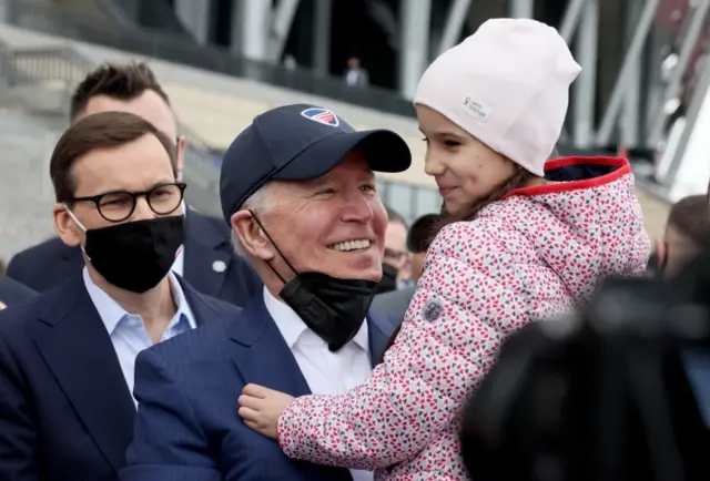 US President Joe Biden holds a young Ukrainian girl in Warsaw