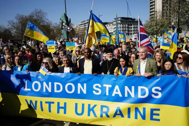 London's mayor Sadiq Khan and other leading politicians and figures from the city hold a banner reading "London stands with Ukraine"