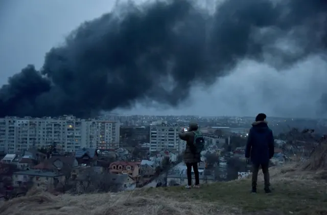 People watch smoke billow over Ukraine