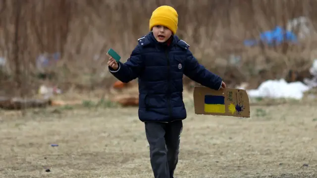 A seven-year-old Ukrainian refugee from Lviv plays outside a temporary shelter in Poland