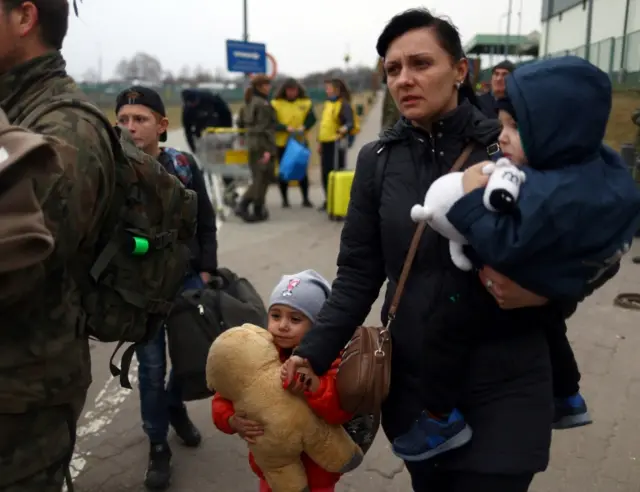 Ukrainian refugees cross the Ukraine-Poland border