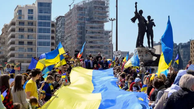 Ukrainians who live in Lebanon hold a huge flag during a demonstration in the capital Beirut