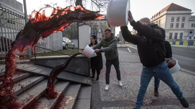 Activists pour red paint on the stairs of the Russian Embassy in Prague on early March 26, 2022.