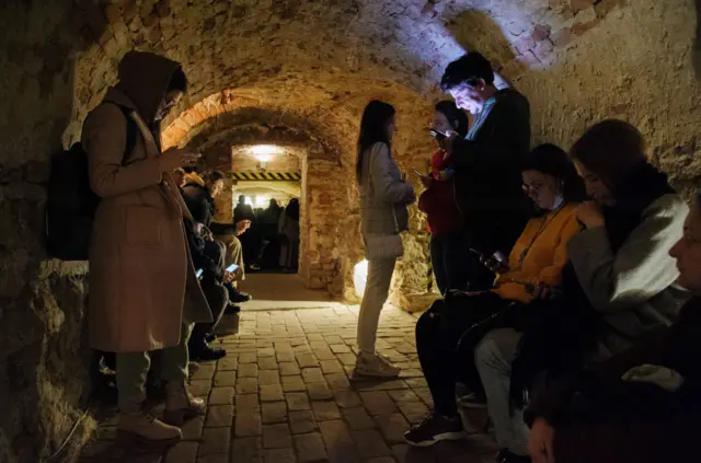 People in a bomb shelter under a historic building in Lviv