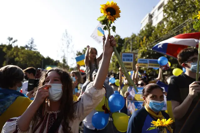 Demonstrators hold sunflowers and flags in support of Ukraine in Chile