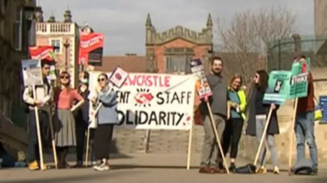 Protestors hold up banners outside Newcastle University