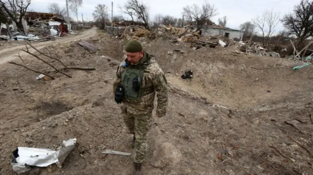 Ukrainian soldier near site of missile impact near Kyiv