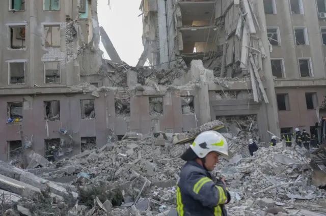 Firefighters clear rubble from a government building hit by a rocket strike in Mykolaiv