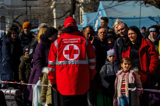 A member of the red cross helps organize refugees from Mariupol