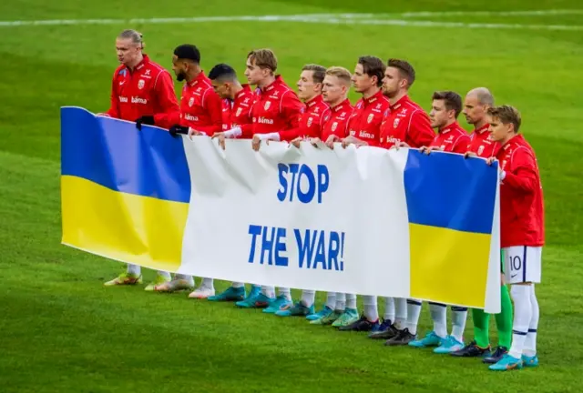 Norway players pose with a stop the war banner