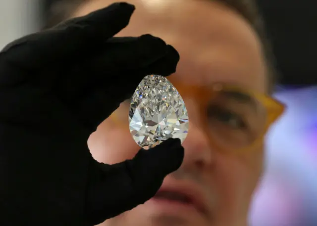 A man inspects a giant diamond called The Rock.