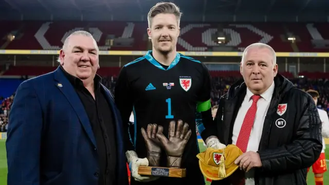 Wayne Hennessey is presented with his 100th cap by Neville Southall