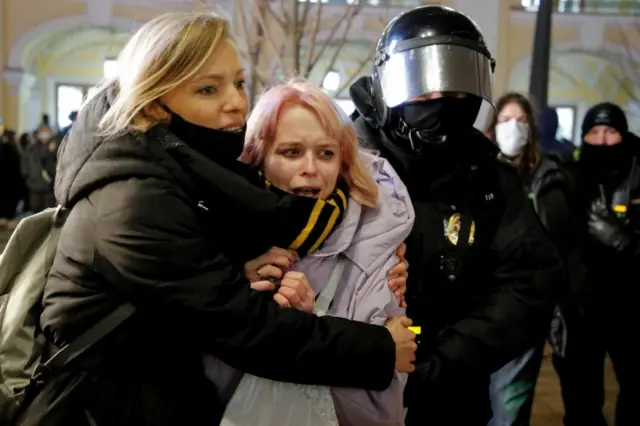 A Russian law enforcement officer detains demonstrators during an anti-war protest against Russia"s invasion of Ukraine, in Saint Petersburg, Russia March 2, 2022