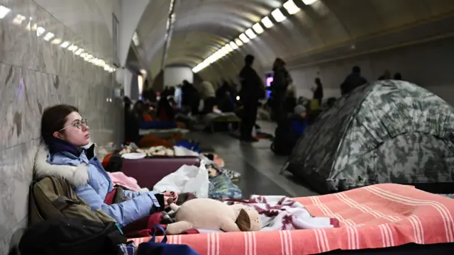 A young woman sits in an underground metro station used as bomb shelter in Kyiv