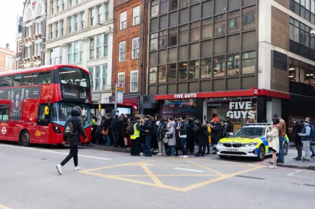 Commuters wait to get on a bus near Liverpool Street Station