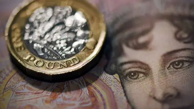 A ten pound note and a one pound coin.