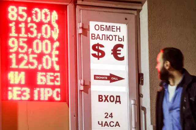 A man in Russia looks at a currency exchange screen