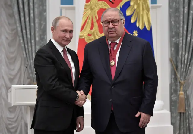 Russian President Vladimir Putin (L) shakes hands with Russian businessman and founder of USM Holdings Alisher Usmanov during an awarding ceremony at the Kremlin in Moscow
