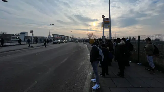 Commuters waiting for the bus at Willesden Junction