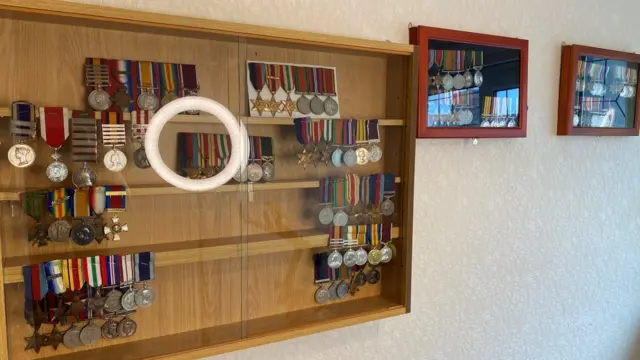 War medals displayed in frames on a wall.