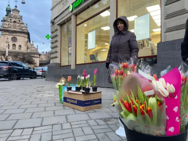 woman in square selling flowers