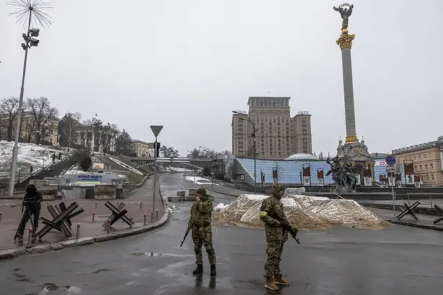 Ukrainian military members stand guard at Independence Square, in Kyiv