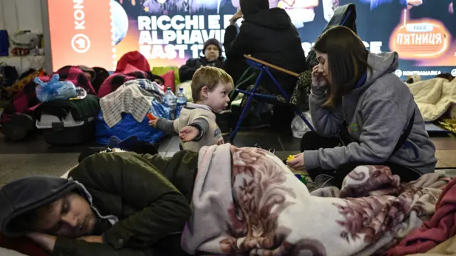 A young boy plays with his sister in an underground metro station used as bomb shelter in Kyiv
