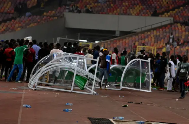 Angry football fans break the players' bench at the National Stadium in Abuja on March 29, 2022