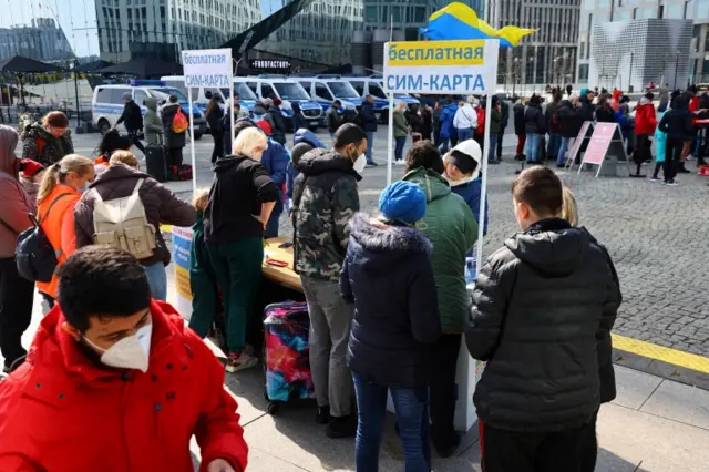 People fleeing from Ukraine queue to receive a German mobile network SIM for free